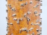 a tall wooden object with metal spikes on it