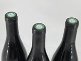 three bottles of wine that are sitting on a table