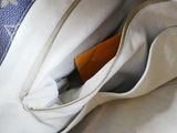 a white purse with a brown tag in it