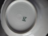 a close up of a white plate with a green design on it
