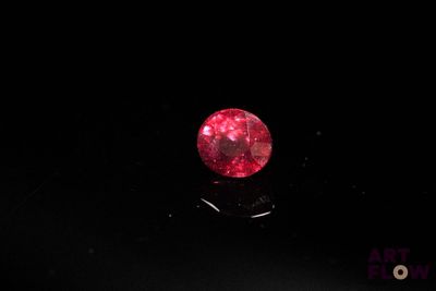 un diamant rouge sur une surface noire