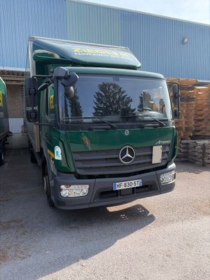 un camion vert garé devant un immeuble