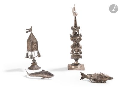 three silver figurines of different shapes and sizes on a white surface