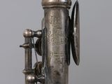 a very old silver saxophone that is on a table