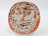a plate with a face on it on a white surface