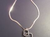 Gros plan sur un collier orné d'une pierre verte