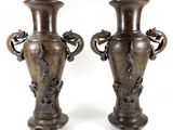 two vases that are sitting side by side on a white surface