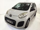 a small white car that is parked in a room