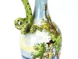 a blue and yellow vase with a green snake on it