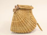a wicker purse with a wooden handle on a white background