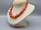 un mannequin blanc orné de perles de corail orange