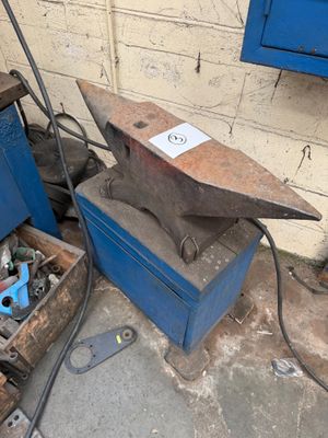 an old anvil sitting in a box next to a blue box