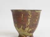 an image of a brown and green bowl sitting on top of a white surface