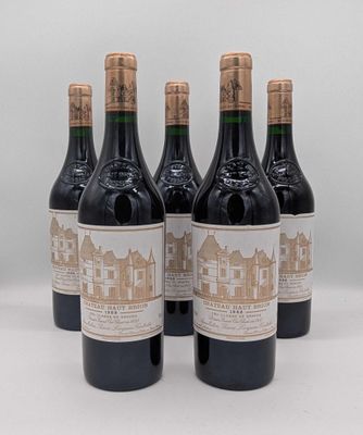six bouteilles de vin sont alignées sur une surface blanche