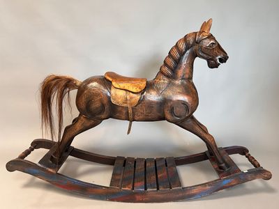 a wooden rocking horse with a saddle on it ' s back