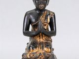 une image représentant une statue d'une personne assise en position de méditation