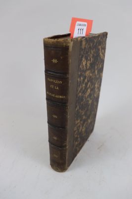 un vieux livre sur lequel est accrochée une étiquette rouge