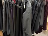 a lot of coats hanging on a rack in a store
