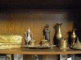 une bibliothèque sur laquelle sont disposés de nombreux objets en laiton