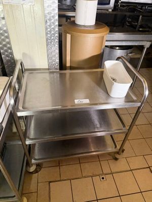 a metal table with a bucket on it in a kitchen