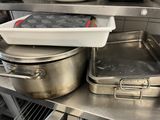 pots and pans sit on a stainless steel counter in a commercial kitchen