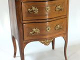 a small marble top chest of drawers on a stand