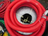 a red hose that is connected to a black pipe