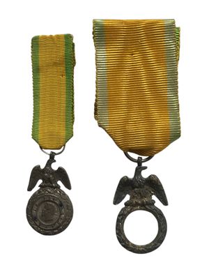 deux médailles et une bague ornée d'un aigle sur fond blanc