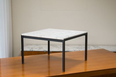 une petite table avec un plateau en marbre posée sur une table en bois