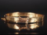 un gros plan d'un bracelet en or orné d'un nœud