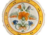 a yellow and blue plate with flowers and birds on it