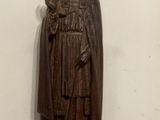 statue en bois représentant un homme portant un chapeau et une cape