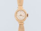 gros plan d'une montre-bracelet en or sur fond blanc