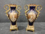 pair of blue and gold vases sitting on top of a table