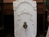 une porte blanche munie d'une poignée dorée, dans une pièce