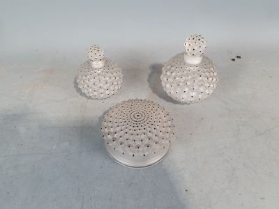 trois petits vases blancs posés par terre, les uns à côté des autres