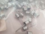 a bunch of silver pins on a white surface