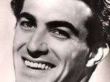 black and white photograph of a smiling man in a suit and tie