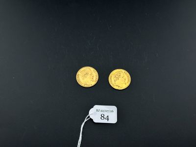 two gold coins and a price tag on a black surface