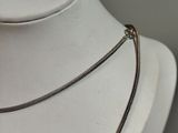 necklace on a mannequin with a chain attached to it ' s neck
