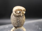 a small figurine of an owl sitting on top of a table