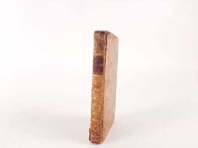 an old book sitting on top of a white surface