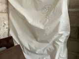 a white sheet with a smiley face on it next to a brown bag