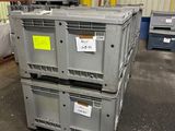 une pile de cartons dans un entrepôt, sur laquelle est accrochée une pancarte jaune