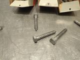 two screws that are sitting on a metal table