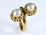 une image représentant une bague en or surmontée de deux perles
