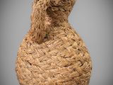 an image of a woven vase with a glass bottle on top