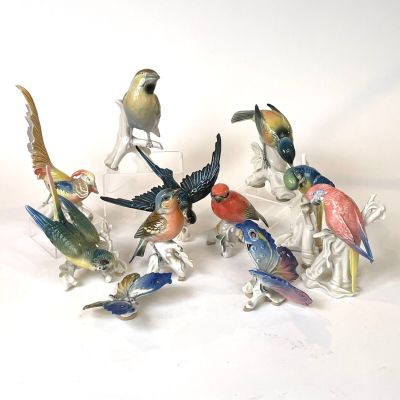 several figurines of birds sitting on top of a white surface
