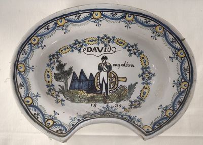 une assiette bleue et blanche sur laquelle est représenté un homme