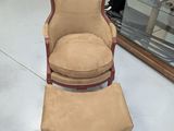 un fauteuil et un pouf dans une pièce où se trouve une vitrine